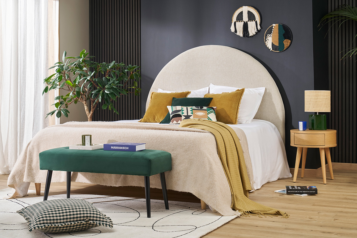 Banc capitonn� en tissu velours vert fonc� et m�tal noir dans une chambre moderne.