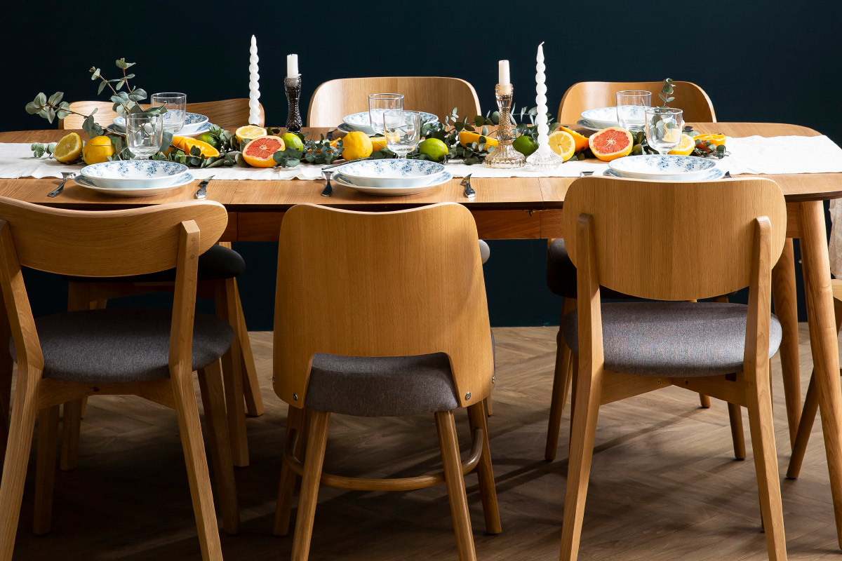 Chaises en bois clair et tissu gris autour d'une table dress�e.