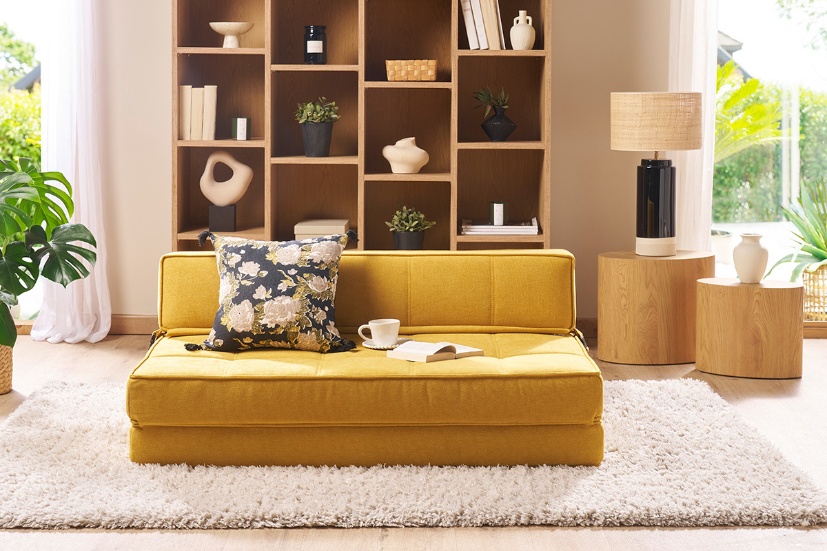 Chauffeuse KATY convertible jaune moutarde avec coussin, vue de face dans un int�rieur moderne.