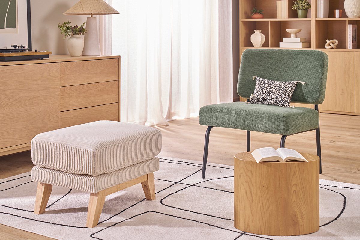 Fauteuil VEDANA vert kaki et m�tal noir, vue de face, avec coussin � motifs, dans un salon.