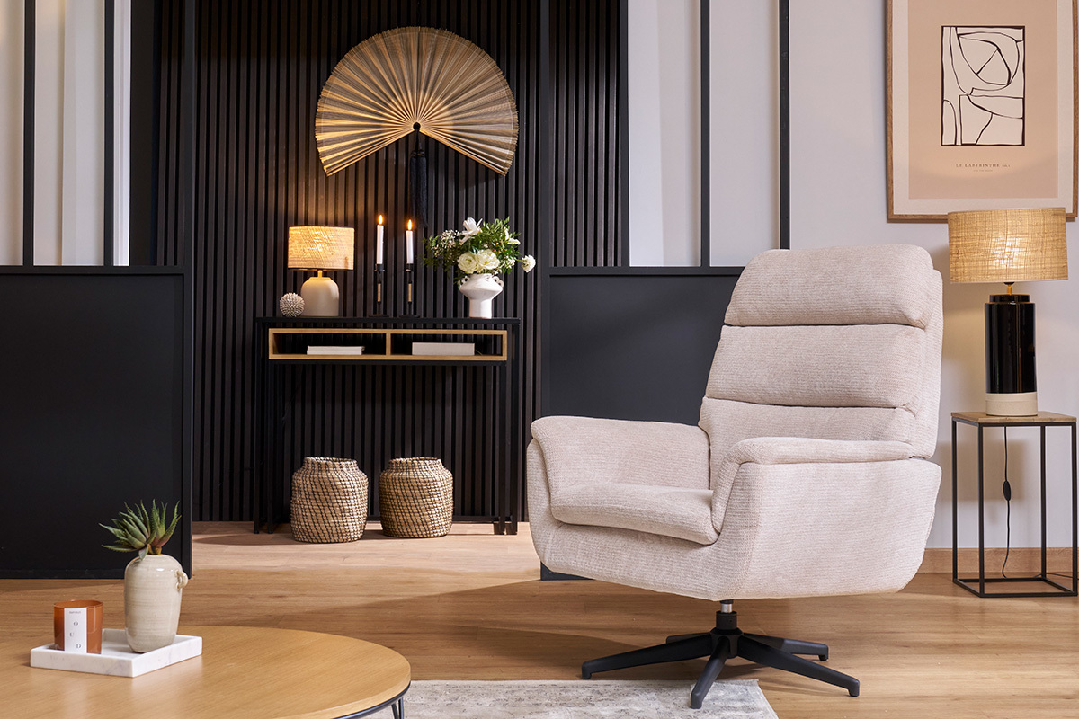 Fauteuil pivotant JONAH en tissu chenille beige, vue de 3/4, avec des �l�ments de d�coration en arri�re-plan.