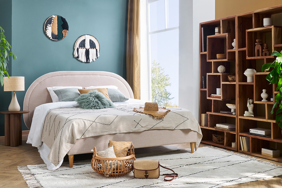 Lit 2 places beige CHARLINE avec t�te arrondie, accessoires d�coratifs autour.