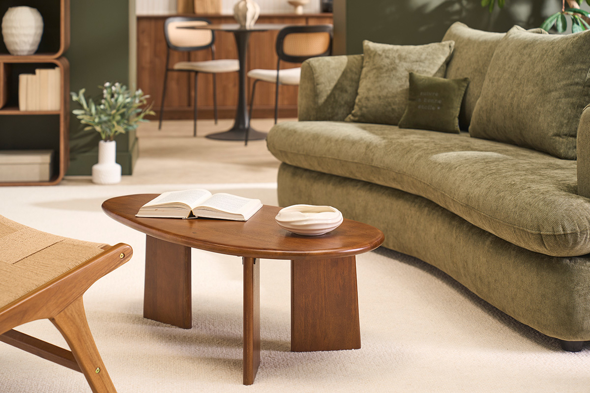 Table basse design en bois manguier massif teint�, forme ovale, vue de dessus avec livre ouvert.