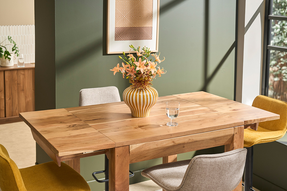 Table de bar haute extensible en bois massif, angle de vue saisissant, d�cor�e avec des fleurs et un verre d'eau.