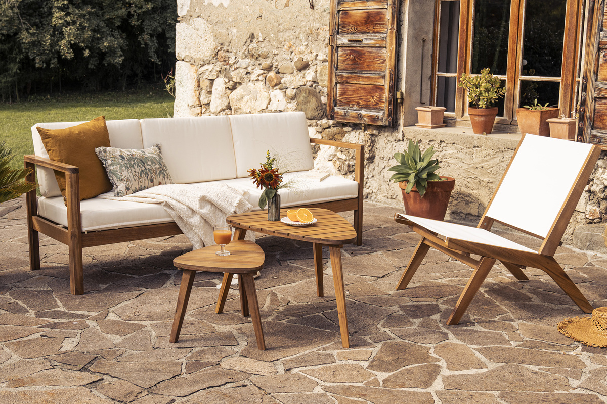 Tables basses gigognes en bois massif, vue depuis le c�t�, sur une terrasse avec canap� et chaise.