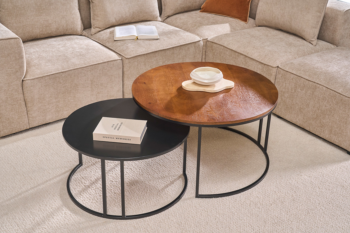 Tables basses gigognes rondes en bois manguier et m�tal noir, pos�es dans un salon moderne.