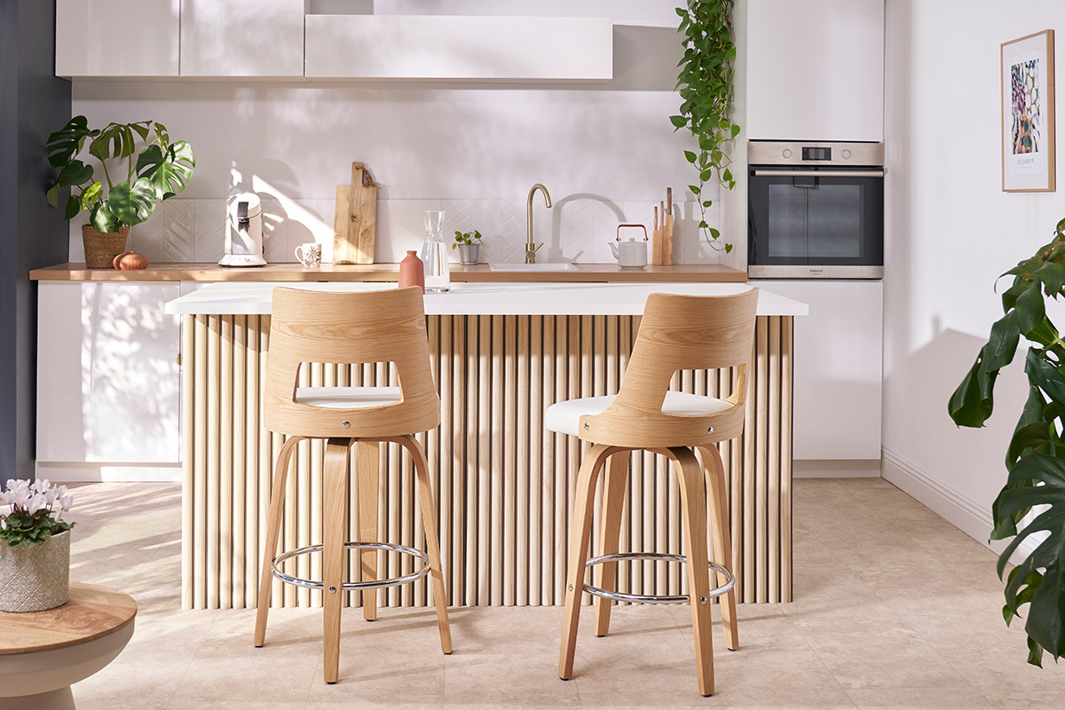 Tabouret de bar scandinave blanc et bois clair, vue de dos dans une cuisine moderne.
