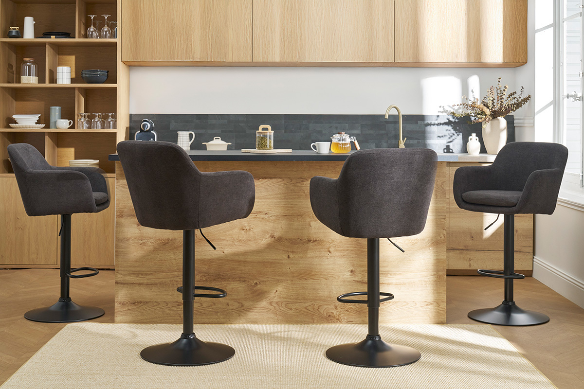 Quatre tabourets de bar gris fonc� en tissu effet velours autour d'un �lot de cuisine en bois.